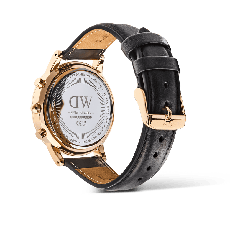 Rear view of the Daniel Wellington Iconic Chronograph watch, showing the engraved rose gold case back and the black leather strap with a rose gold pin buckle.