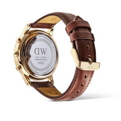 Detail of the Daniel Wellington Iconic Chronograph St Mawes Gold watch, showing the engraved caseback and brown leather strap.