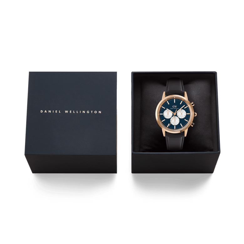 The Daniel Wellington Iconic Chronograph Sheffield watch in rose gold, featuring an Arctic blue panda dial and black leather strap, presented inside its black brand box.