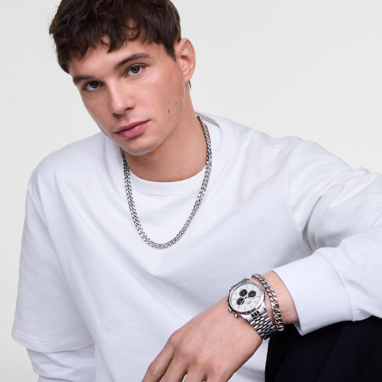 Male model wearing the Daniel Wellington Iconic Chronograph Arch 5-Link watch with an off-white panda dial and silver link bracelet.